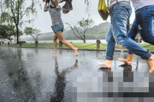昨天傍晚，杭州下起雷阵雨，西湖边，一群姑娘赤脚跑过。 记者 陈荣辉 摄