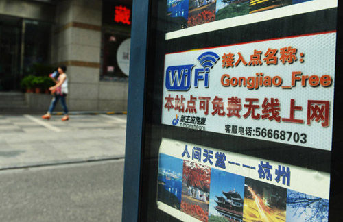 市民从杭州一公交站点的“本站点可免费无线上网”标签边上走过