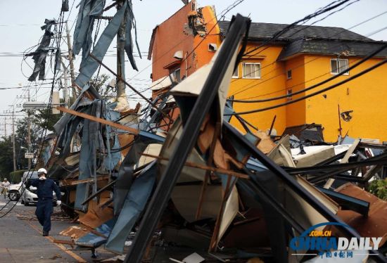 9月2日，日本埼玉县越谷市，一名警察走过遭到疑为龙卷风暴风袭击的房屋。