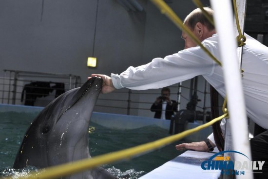 俄总统普京访问海洋馆 与小动物“亲密接触”