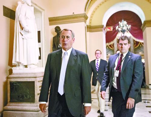 图说：28日，美众议院连夜讨论预算法案。图为议长博纳（左）步入会议室。