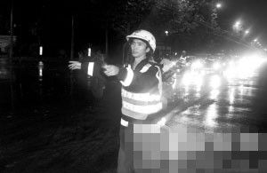 昨晚9：20，莫干山路教工路口，交警在雨中指挥交通。 记者 胡聪 摄