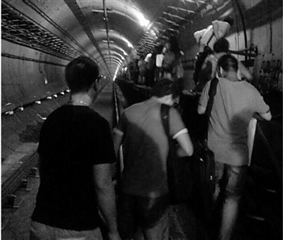 昨晚8点半左右，滞留在江底的乘客，沿着地铁隧道步行疏散。