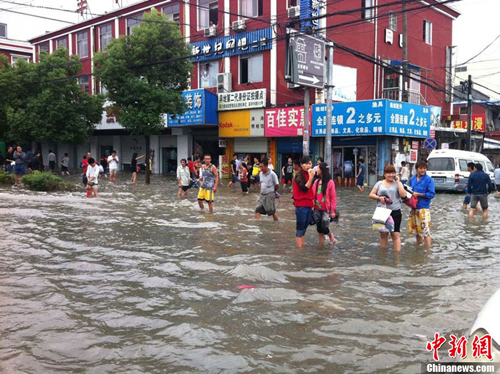 图为宁波内涝严重，多处积水，市民涉水出行。何蒋勇 摄
