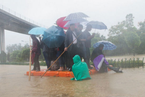 杭州市民自制桶筏 冒着暴雨在积水上渡人