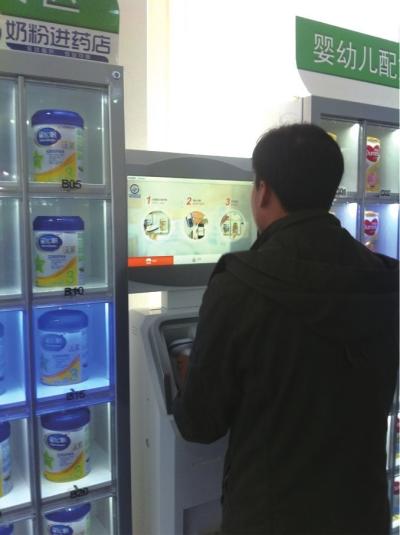 　▲23日，工作人员现场展示用于销售奶粉的药店自动售卖机。