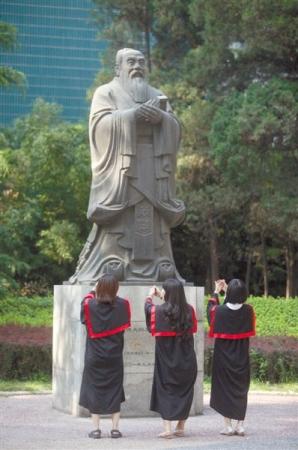 中国人民大学几名毕业生在离校前“拜别”孔子像。新京报记者 薛珺 摄