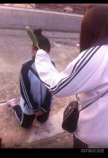 网上流传的照片显示，一名女生拿着黄瓜正教训跪在地上的女生