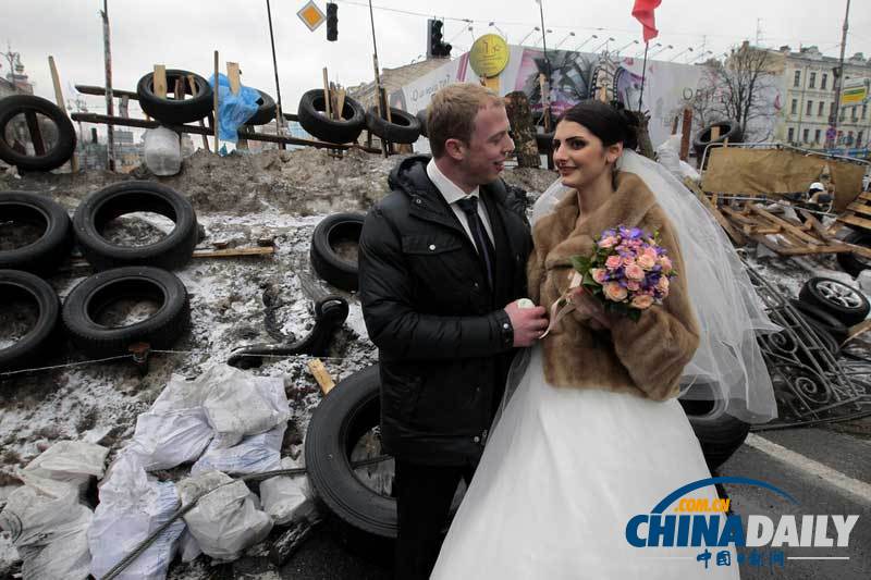 当地时间2013年12月21日，乌克兰基辅，一对新人在独立广场的示威人群中成婚。（图片来源：东方IC）