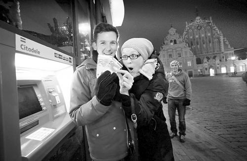 1日，一对拉脱维亚情侣从取款机中取出欧元。