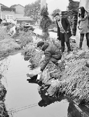 环保志愿者在冀发集团门口的水沟里取样。